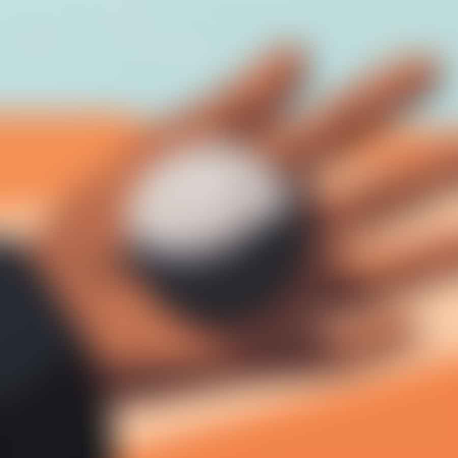 A close-up of a player's hand gripping a Petanque boule